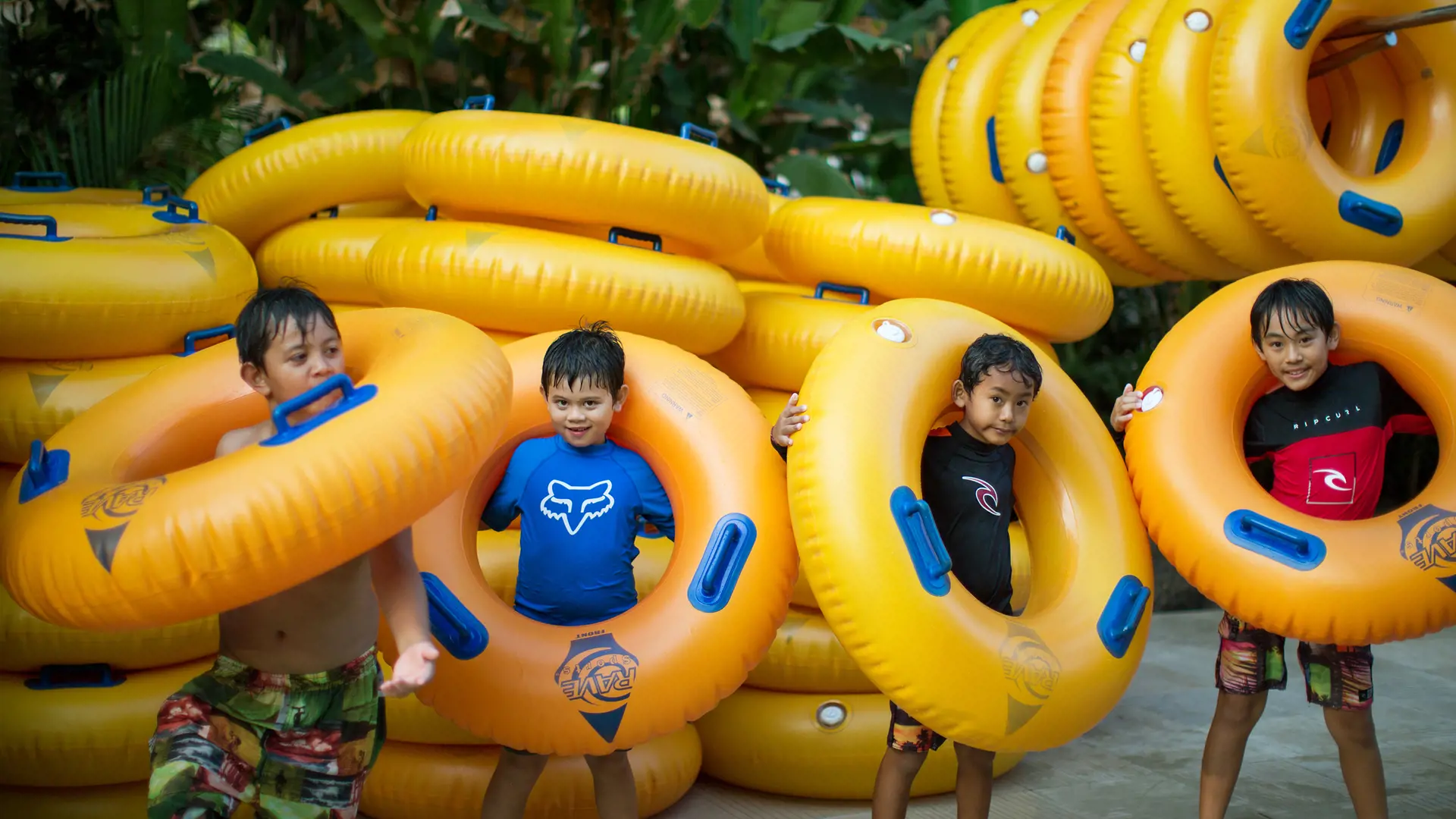 Kids posing with orange rubber tubes at Waterbom Bali